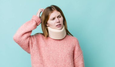 Kızıl saçlı güzel kadın mutlu bir şekilde gülümsüyor ve hayal kuruyor ya da şüphe ediyor. kaza tasması konsepti