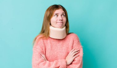 Kızıl saçlı güzel kadın omuz silkiyor, kafası karışık ve kararsız. kaza tasması konsepti