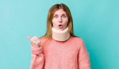 Kızıl saçlı, güzel bir kadın inançsızlıktan şaşkın şaşkın bakıyor. kaza tasması konsepti