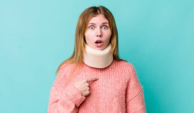 Kızıl saçlı güzel kadın şok olmuş ve ağzı açık, kendini işaret eden bir şekilde şaşırmış görünüyor. kaza tasması konsepti