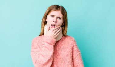 Kızıl saçlı, ağzı ve gözleri açık, eli çenesinde güzel bir kadın. kaza tasması konsepti