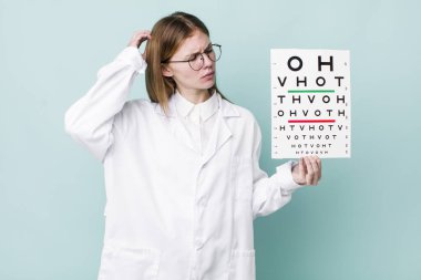 Kızıl saçlı güzel kadın şaşkın ve kafası karışık, kaşınan bir kafa hissediyor. optik görüş testi konsepti