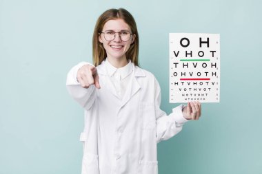 Kızıl saçlı güzel kadın kamerayı işaret ederek seni seçiyor. optik görüş testi konsepti