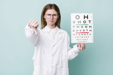 Kızıl saçlı, güzel bir kadın kendini kötü hissediyor, baş parmağını kaldırıyor. optik görüş testi konsepti