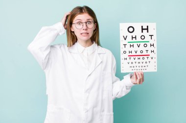 Kızıl saçlı güzel kadın stresli, endişeli ya da korkmuş, elleri başının üstünde. optik görüş testi konsepti