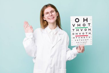 Kızıl saçlı güzel kadın mutlu bir şekilde gülümsüyor, el sallıyor, seni selamlıyor ve selamlıyor. optik görüş testi konsepti