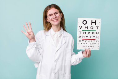 Kızıl saçlı güzel kadın gülümsüyor ve arkadaş canlısı görünüyor, dört numarayı gösteriyor. optik görüş testi konsepti