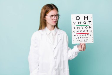 Kızıl saçlı, güzel bir kadın üzgün, üzgün ya da kızgın ve yana bakıyor. optik görüş testi konsepti