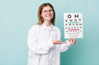 kızıl saçlı güzel bir kadın neşeli bir şekilde gülümsüyor, mutlu hissediyor ve bir konsept gösteriyor. optik görüş testi konsepti