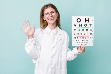 Kızıl saçlı güzel kadın gülümsüyor ve arkadaş canlısı görünüyor, beş numarayı gösteriyor. optik görüş testi konsepti