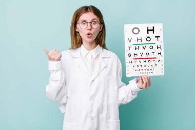 Kızıl saçlı, güzel bir kadın inançsızlıktan şaşkın şaşkın bakıyor. optik görüş testi konsepti