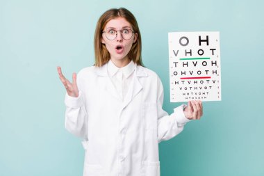 Kızıl saçlı güzel kadın inanılmaz bir sürprizle şaşkına dönmüş ve hayrete düşmüştü. optik görüş testi konsepti