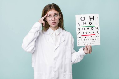 Kızıl saçlı güzel kadın şaşırmış görünüyor, yeni bir düşünce, fikir ya da konsept fark ediyor. optik görüş testi konsepti