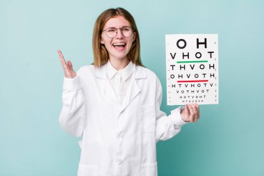 Kızıl saçlı güzel kadın kendini mutlu hissediyor, bir çözüm ya da fikir bulduğuna şaşırıyor. optik görüş testi konsepti