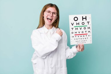 Kızıl saçlı güzel bir kadın kendini mutlu hissediyor ve bir meydan okumayla yüzleşiyor ya da kutluyor. optik görüş testi konsepti