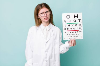 Kızıl saçlı güzel kadın şaşkın ve şaşkın hissediyor. optik görüş testi konsepti