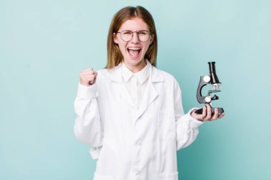 red head pretty woman feeling shocked,laughing and celebrating success. scientist with microscope concept