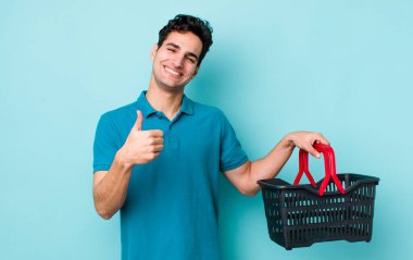 Yakışıklı İspanyol adam gururlu, olumlu gülümsüyor. Alışveriş sepeti konsepti