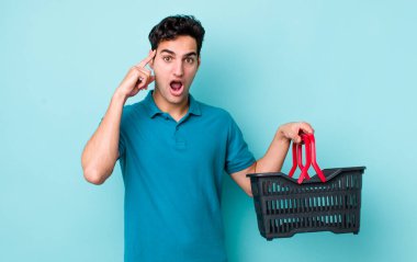 Yakışıklı İspanyol adam şaşırmış görünüyor, yeni bir düşünce, fikir ya da konsept keşfediyor. Alışveriş sepeti konsepti