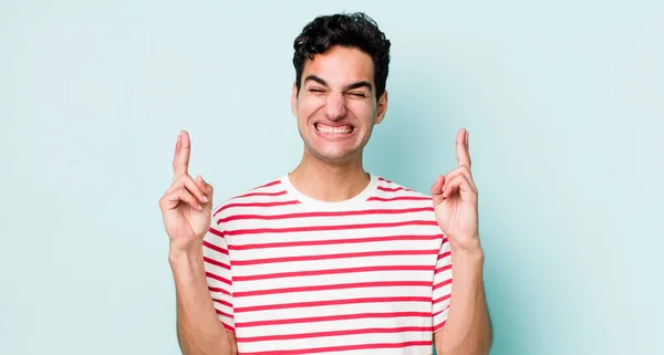 Hombre Hispano Guapo Sonriendo Ansiosamente Cruzando Ambos Dedos Sintiéndose Preocupado — Foto de Stock