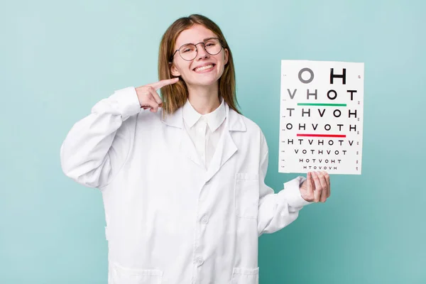 red head pretty woman smiling confidently pointing to own broad smile. optical vision test concept