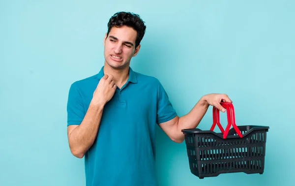 ハンサムなヒスパニック系の男は ストレス 疲れや不満を感じている ショッピングバスケットのコンセプト — ストック写真