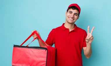 Yakışıklı İspanyol adam gülümsüyor ve mutlu görünüyor, zafer ya da barış işareti yapıyor. Pizza dağıtımı kavramı