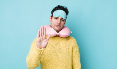 Yakışıklı İspanyol ciddi görünüyor. Avuç içi gösteriyor. Durdurma hareketi yapıyor. uçuş yolcu kavramı