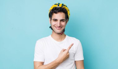 Yakışıklı İspanyol adam neşeyle gülümsüyor, mutlu hissediyor ve bir tarafı işaret ediyor. motor konsepti