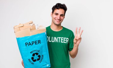 Yakışıklı İspanyol adam gülümsüyor ve arkadaş canlısı görünüyor, üç numarayı gösteriyor. ekoloji kavramı