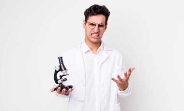 Yakışıklı, İspanyol görünümlü, sinirli ve hayal kırıklığına uğramış mikroskop konsepti olan bilim adamı.