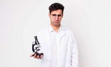 Yakışıklı İspanyol bir adam üzgün ve mızmız görünüyor ve ağlıyor mikroskop konsepti olan bir bilim adamı.