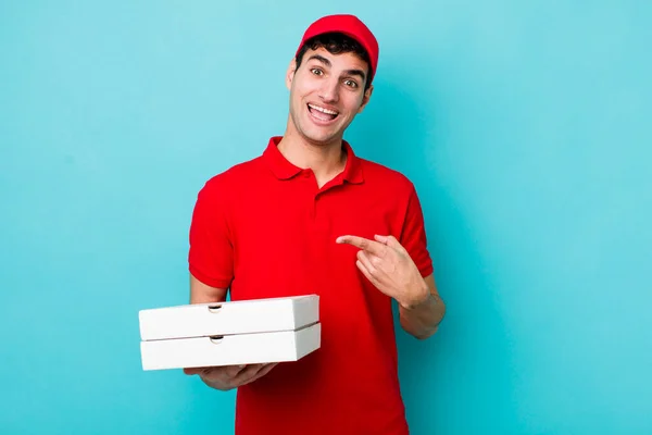 英俊的惊慌失措的男人面带微笑地指着旁边 显得兴奋而惊讶 送披萨的概念 — 图库照片