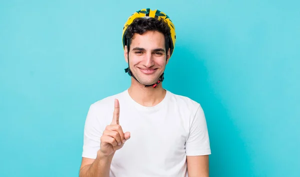 ハンサムなヒスパニック系の男は誇らしげに笑顔と自信を持ってナンバーワンを作る 自転車のコンセプト — ストック写真