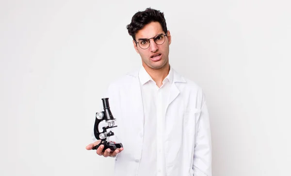 Hombre Hispano Guapo Sintiéndose Desconcertado Confundido Científico Con Concepto Microscopio — Foto de Stock