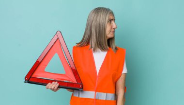 Profil görünümlü yaşlı gri saçlı kadın hayal mi kuruyor yoksa hayal mi kuruyor? araba üçgeni kaza konsepti