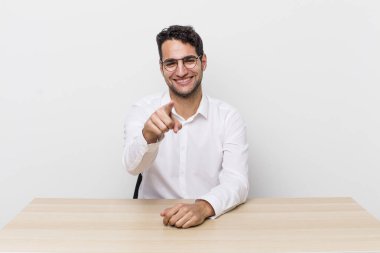İspanyol yakışıklı adam kamerayı göstererek seni seçiyor. iş adamı ve masa başı konsepti