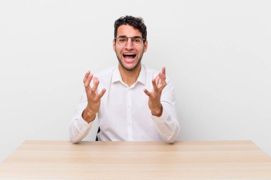 İspanyol yakışıklı adam umutsuz, sinirli ve stresli görünüyor. iş adamı ve masa başı konsepti