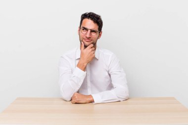 İspanyol yakışıklı düşünen, kuşkucu ve kafası karışık bir adam. iş adamı ve masa başı konsepti