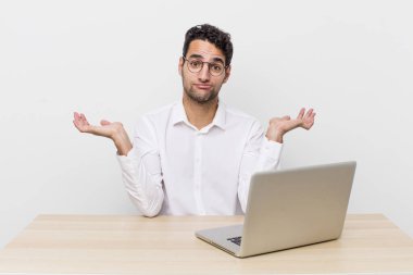 İspanyol yakışıklı adam şaşkın, şaşkın ve şüpheci hissediyor. iş adamı ve masa başı konsepti
