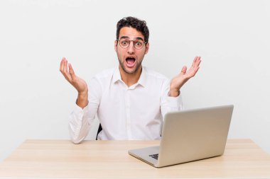 İspanyol yakışıklı adam inanılmaz bir sürprizle şaşkına dönmüş ve hayrete düşmüştü. iş adamı ve masa başı konsepti