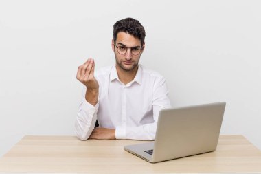 İspanyol yakışıklı adam kapiş ya da para hareketi yapıyor, sana ödemeni söylüyor. iş adamı ve masa başı konsepti