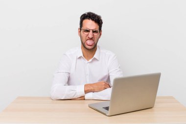 İspanyol yakışıklı adam iğreniyor, sinirleniyor ve dili dışarı çıkıyor. iş adamı ve masa başı konsepti