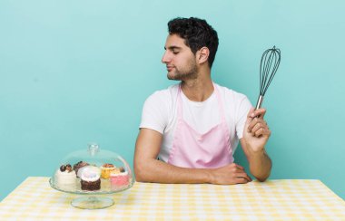 Profil görünümlü İspanyol yakışıklı adam hayal mi kuruyor, hayal mi kuruyor, hayal mi kuruyor? Ev yapımı pastalar.