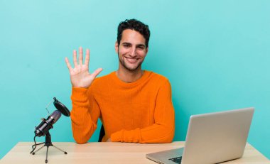 İspanyol yakışıklı adam gülümsüyor ve arkadaş canlısı görünüyor, beş numarayı gösteriyor. Etkilendirici kavramı