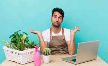 İspanyol yakışıklı adam şaşkın, şaşkın ve şüpheci hissediyor. bahçe ve bitki konsepti