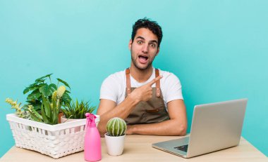 İspanyol yakışıklı adam heyecanlı ve şaşırmış görünüyor. bahçe ve bitki konsepti