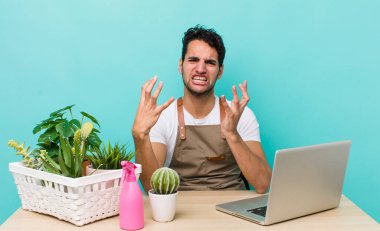 İspanyol yakışıklı adam umutsuz, sinirli ve stresli görünüyor. bahçe ve bitki konsepti