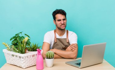 İspanyol yakışıklı adam şaşkın ve şaşkın hissediyor. bahçe ve bitki konsepti