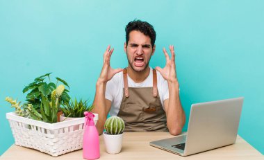 İspanyol yakışıklı adam ellerini havaya kaldırarak bağırıyor. bahçe ve bitki konsepti